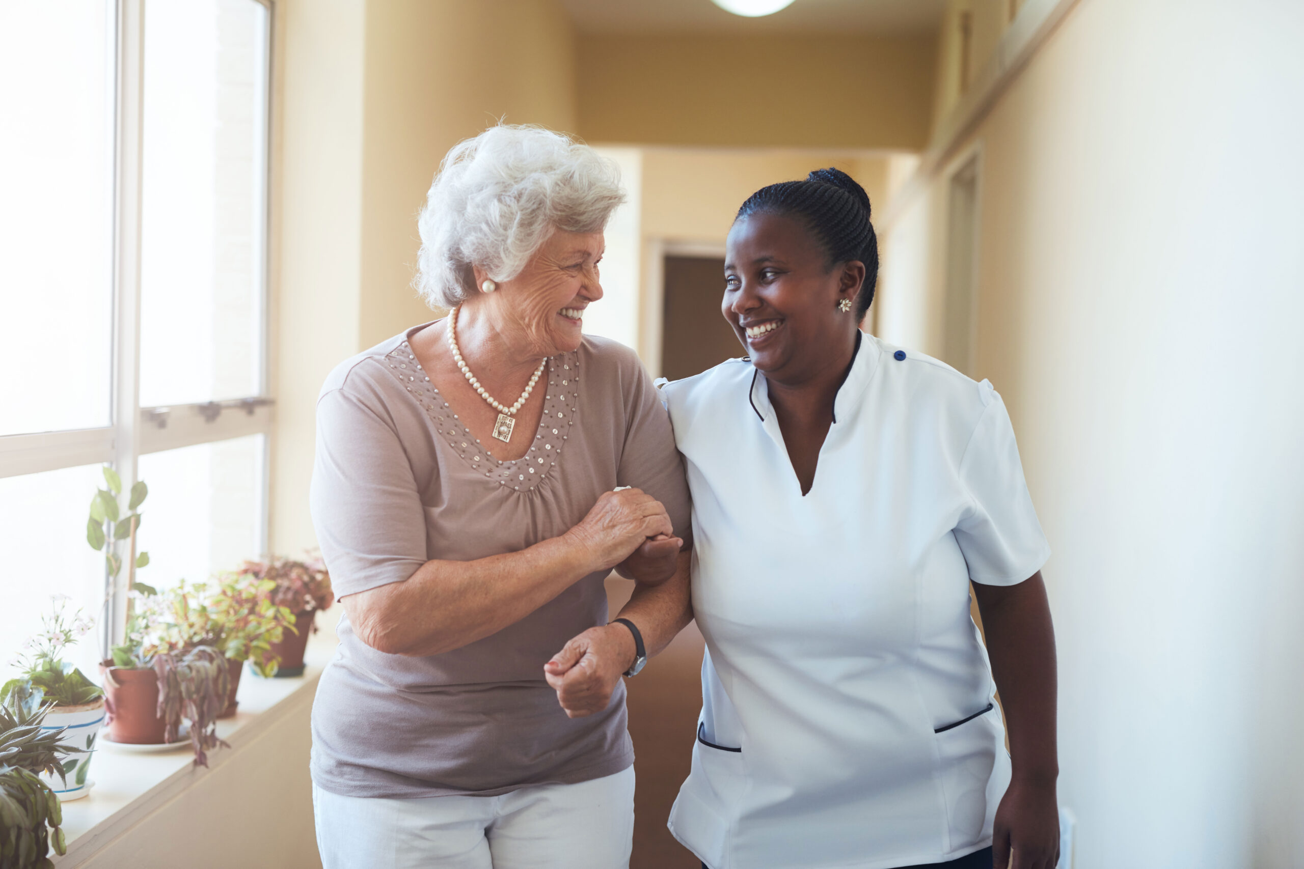 medical care aide supporting senior woman