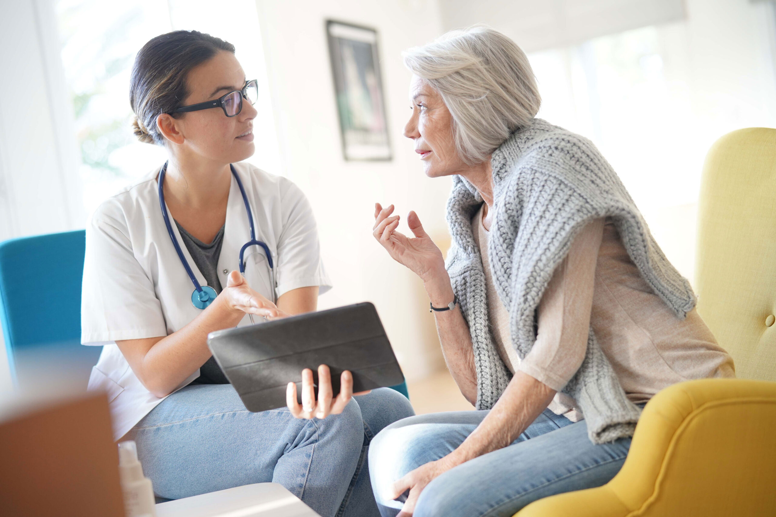 care aide explaining in home technology to elderly woman