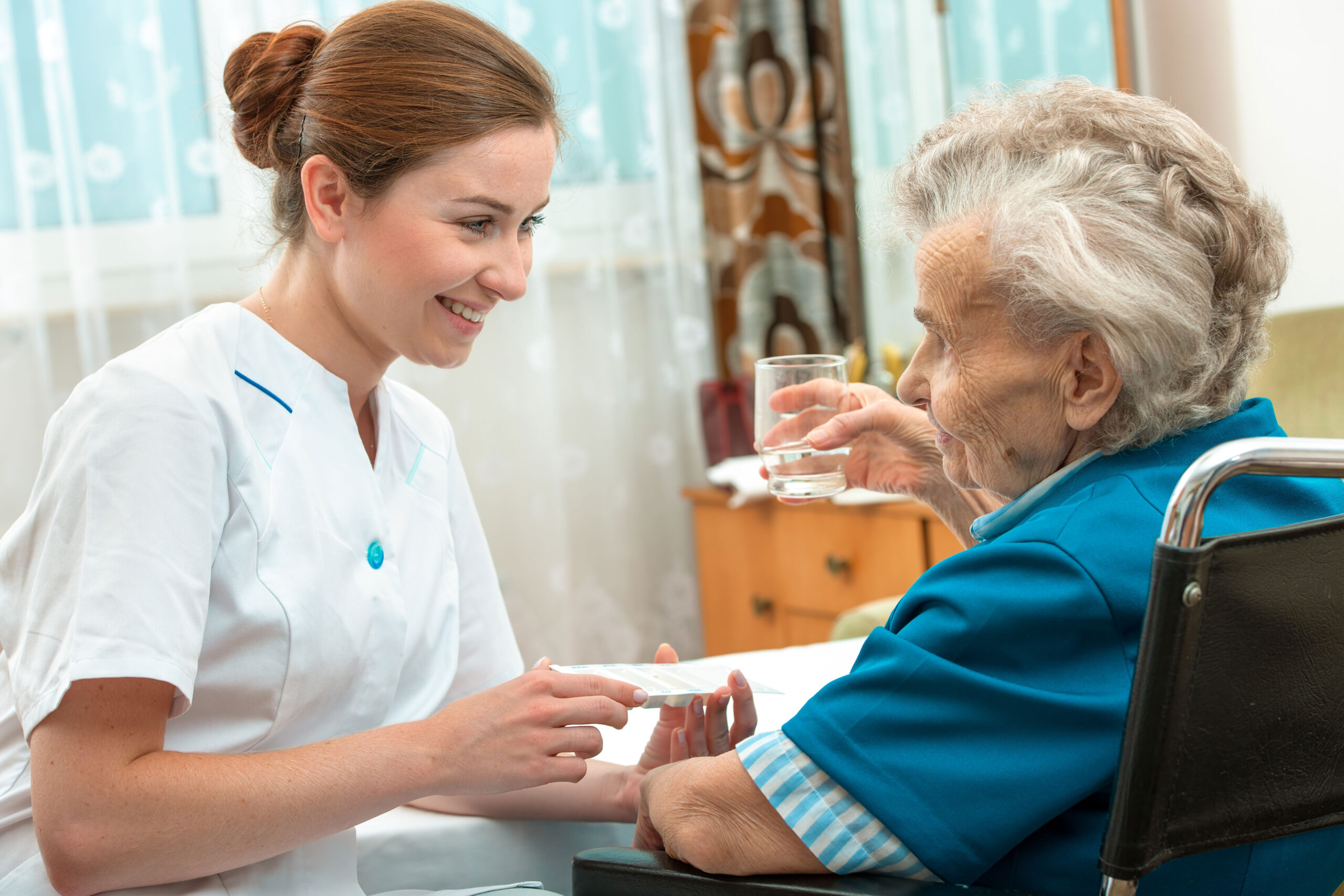 home care aide helping elderly woman with medication management