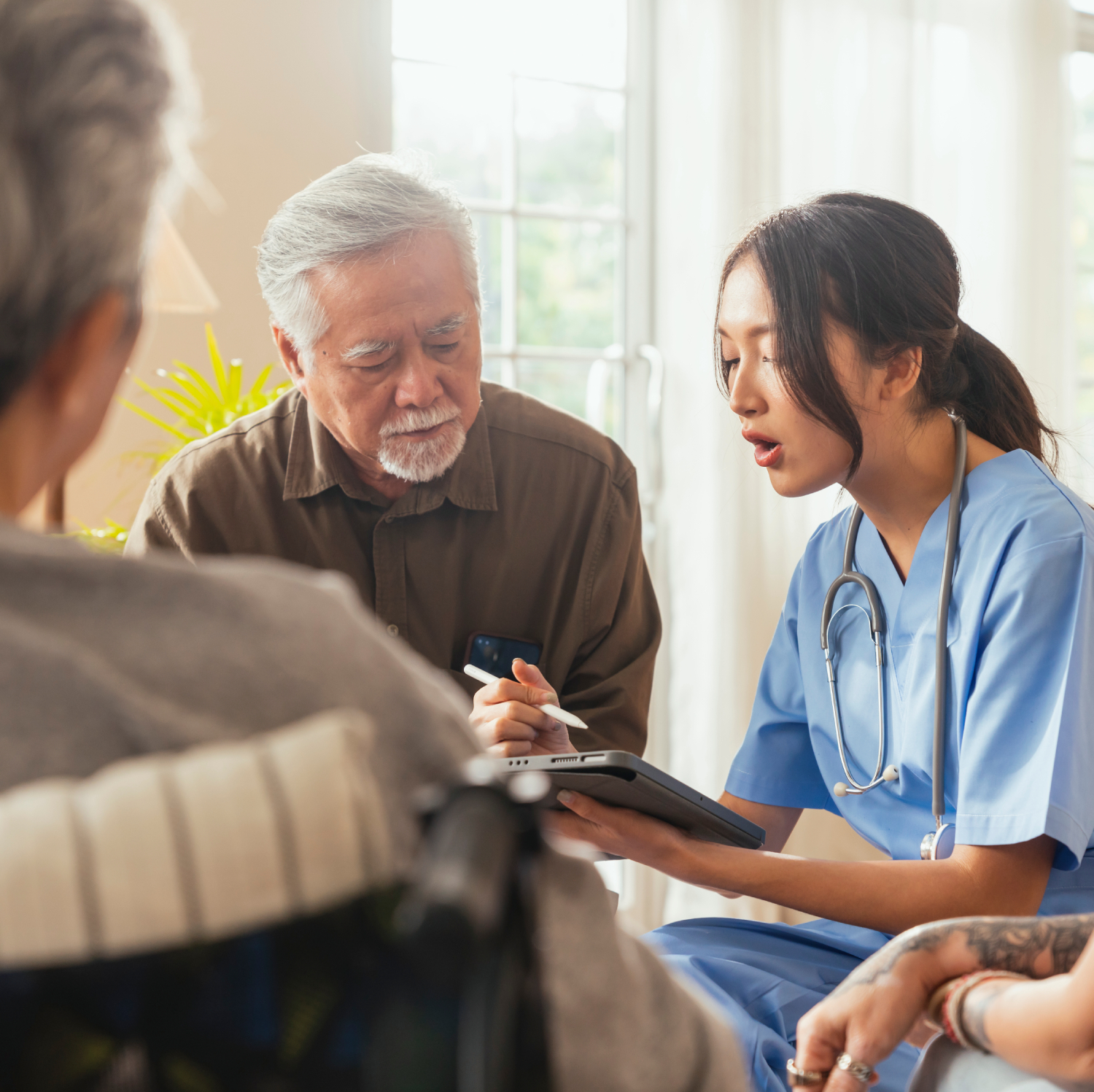 in home healthcare aide speaking with senior and family