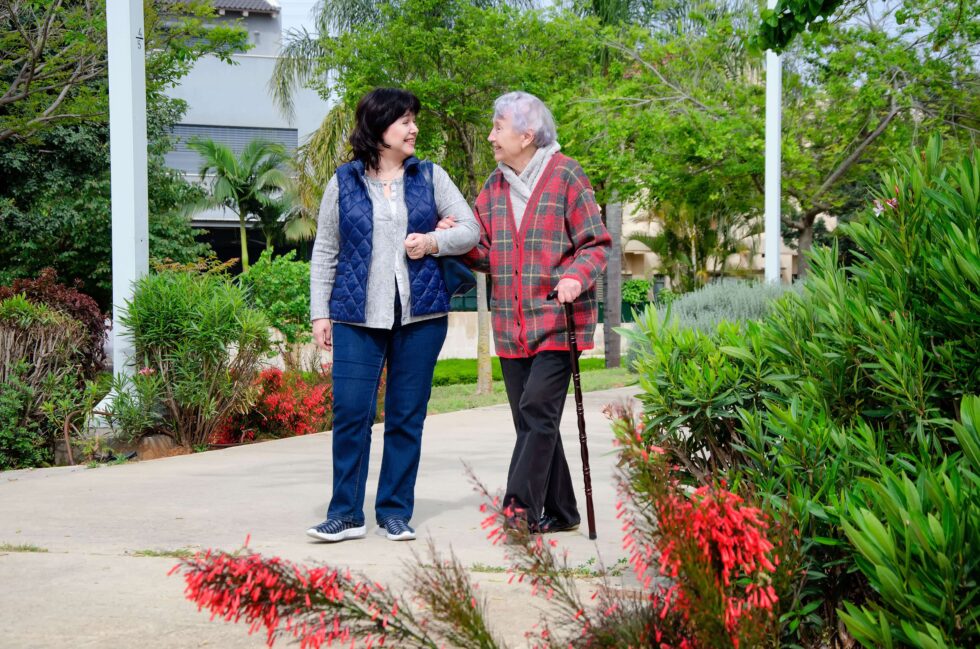 companion care aide walking with elderly woman